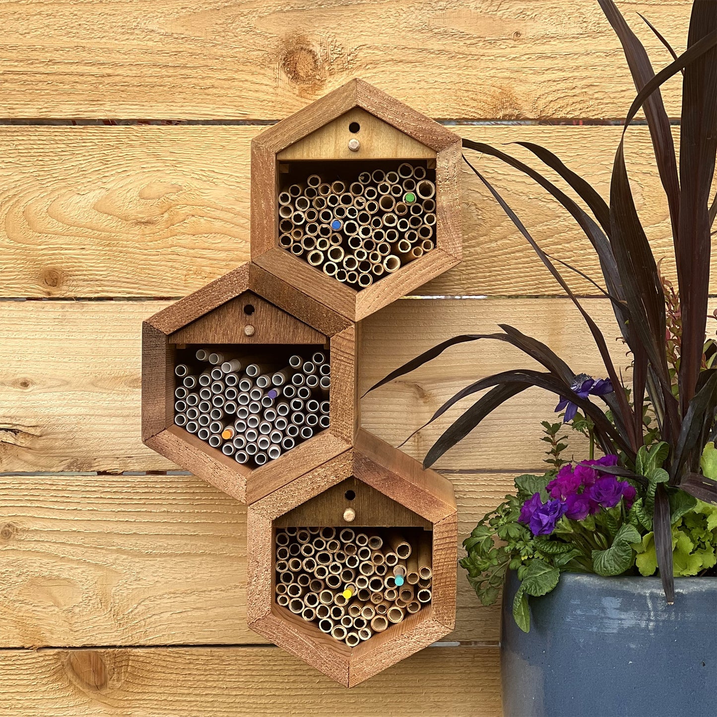Three-tiered section of the Cabana & Mixed Reeds Bee House mounted on a wall