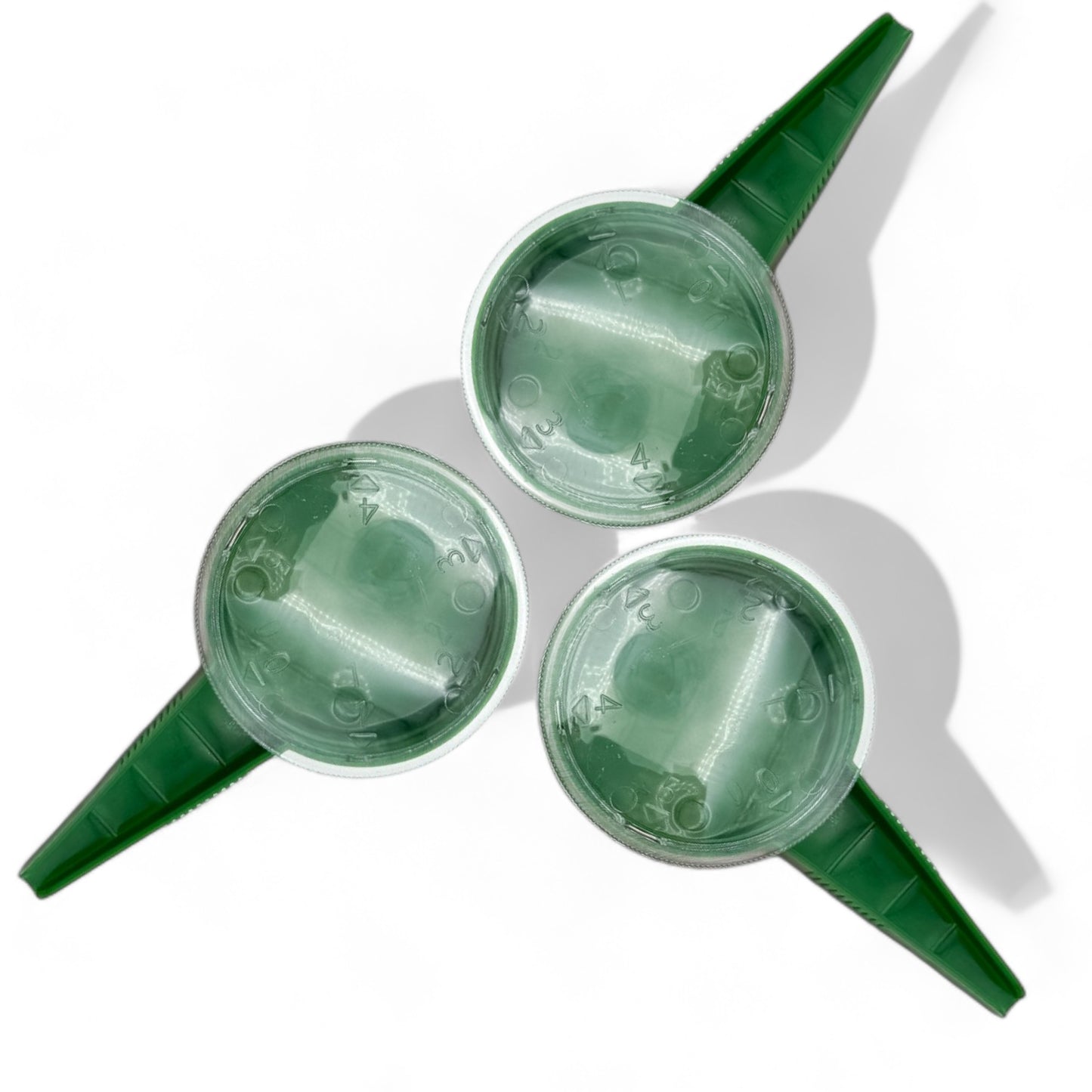 Set of three handheld seed dispensers with handles on white background
