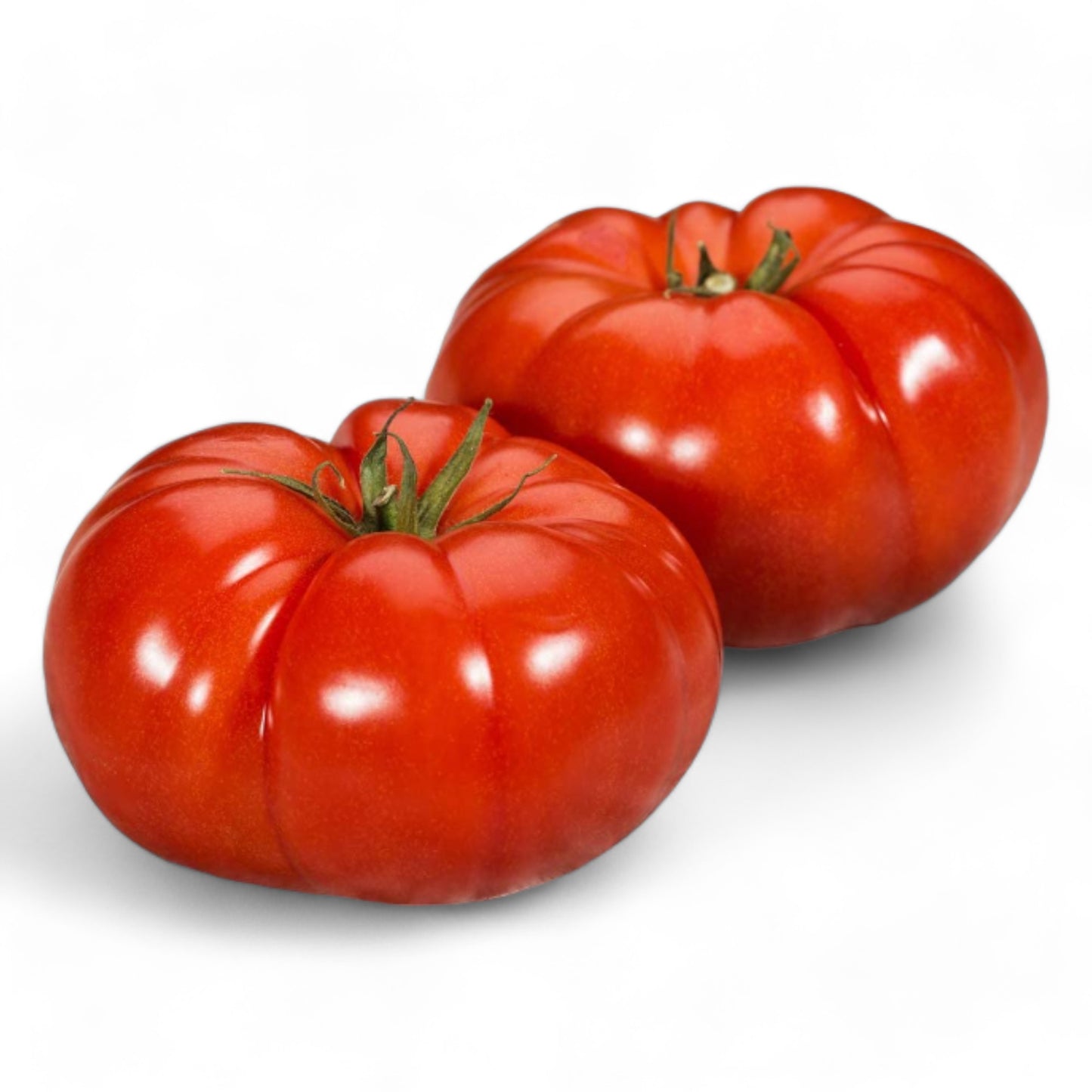 Two Heirloom 'Delicious' tomatoes displayed against a white backdrop