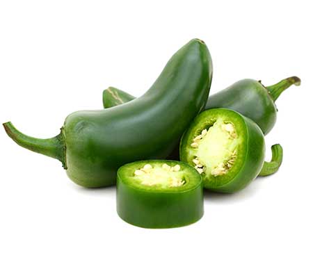 Two fully grown Jalapeno Peppers and one sliced in half to show the inside