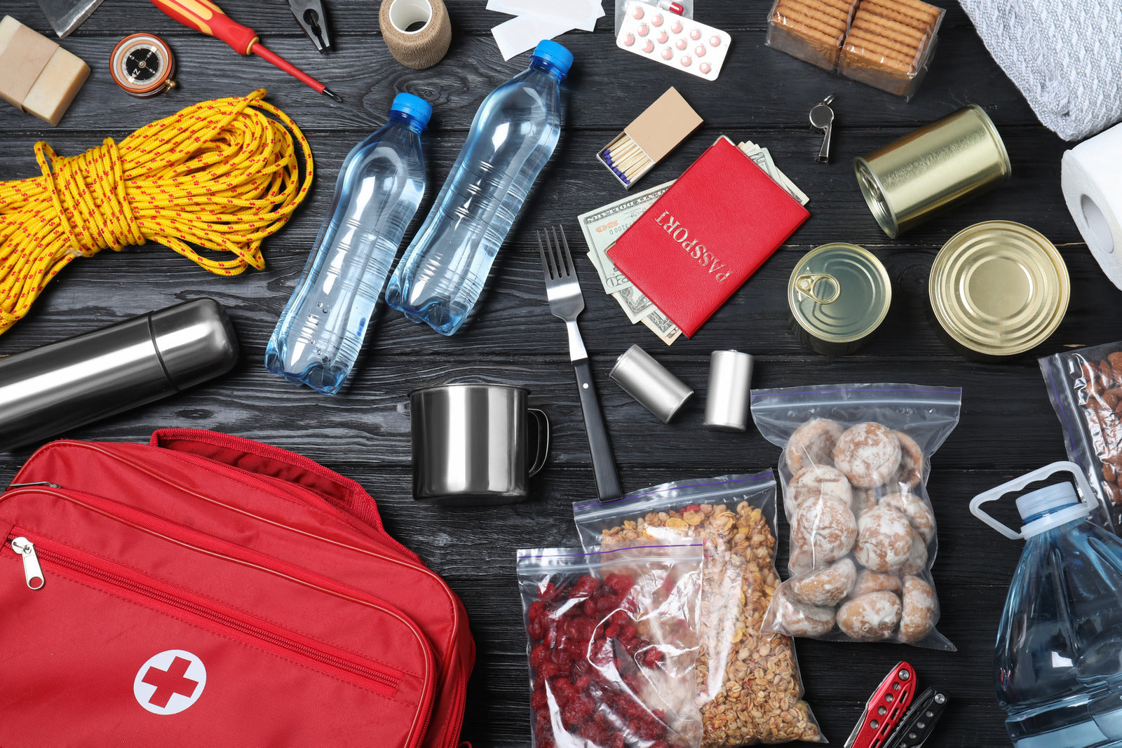 Emergency items laid out on a black wooden surface