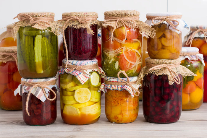 Canning jars filled with various fruits and vegetables