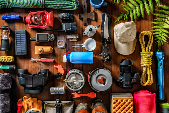 A plethora of survival gear on a wooden table