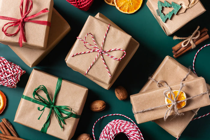 Wrapped gifts with festive them on a green surface
