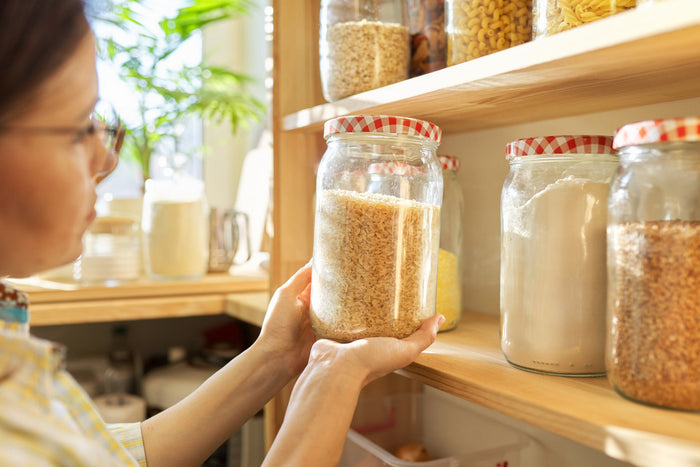 A woman holding a jar of preserved food