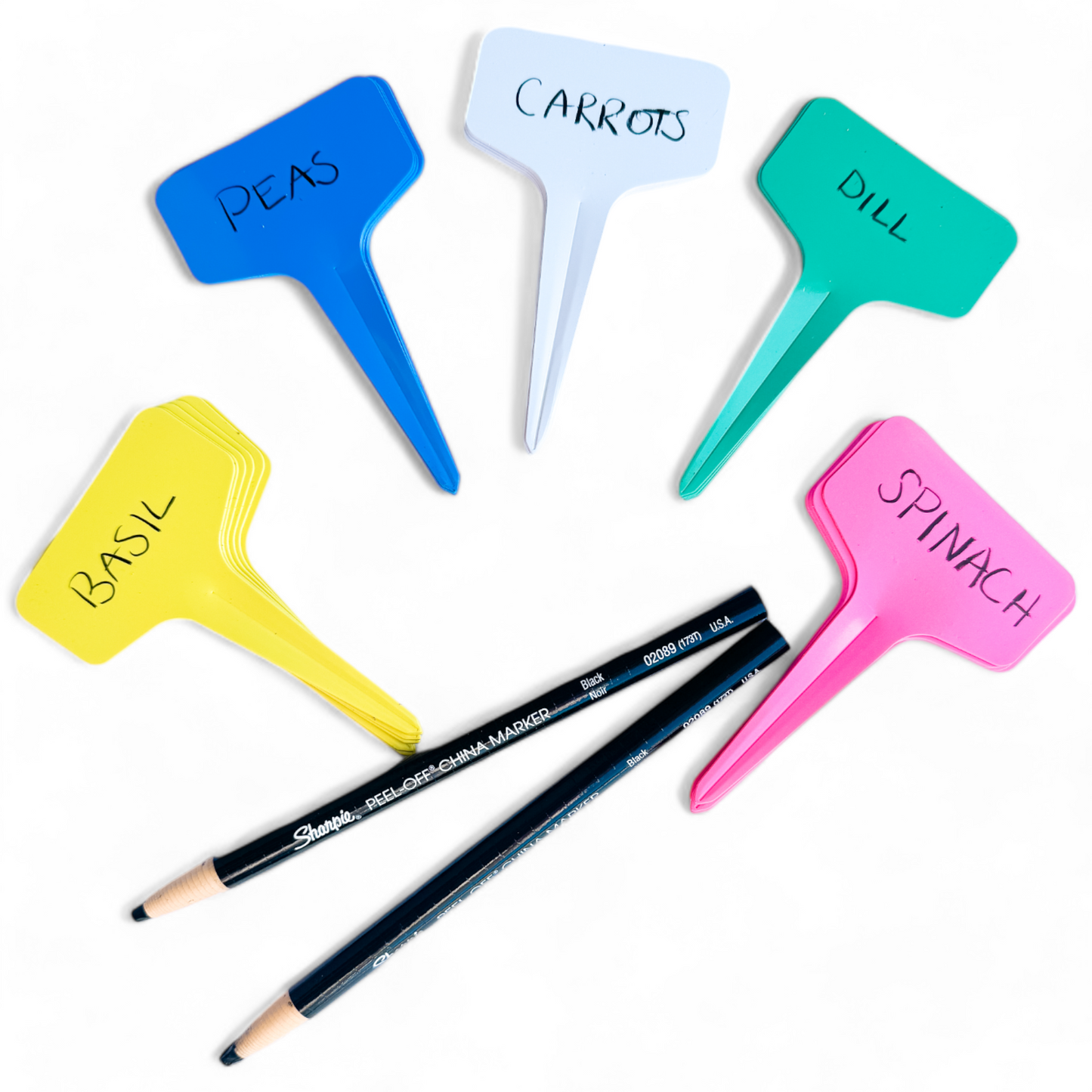 A collection of four plant labels in various colors with two Sharpie pencils