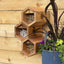 Three-tiered section of the Cabana & Mixed Reeds Bee House mounted on a wall