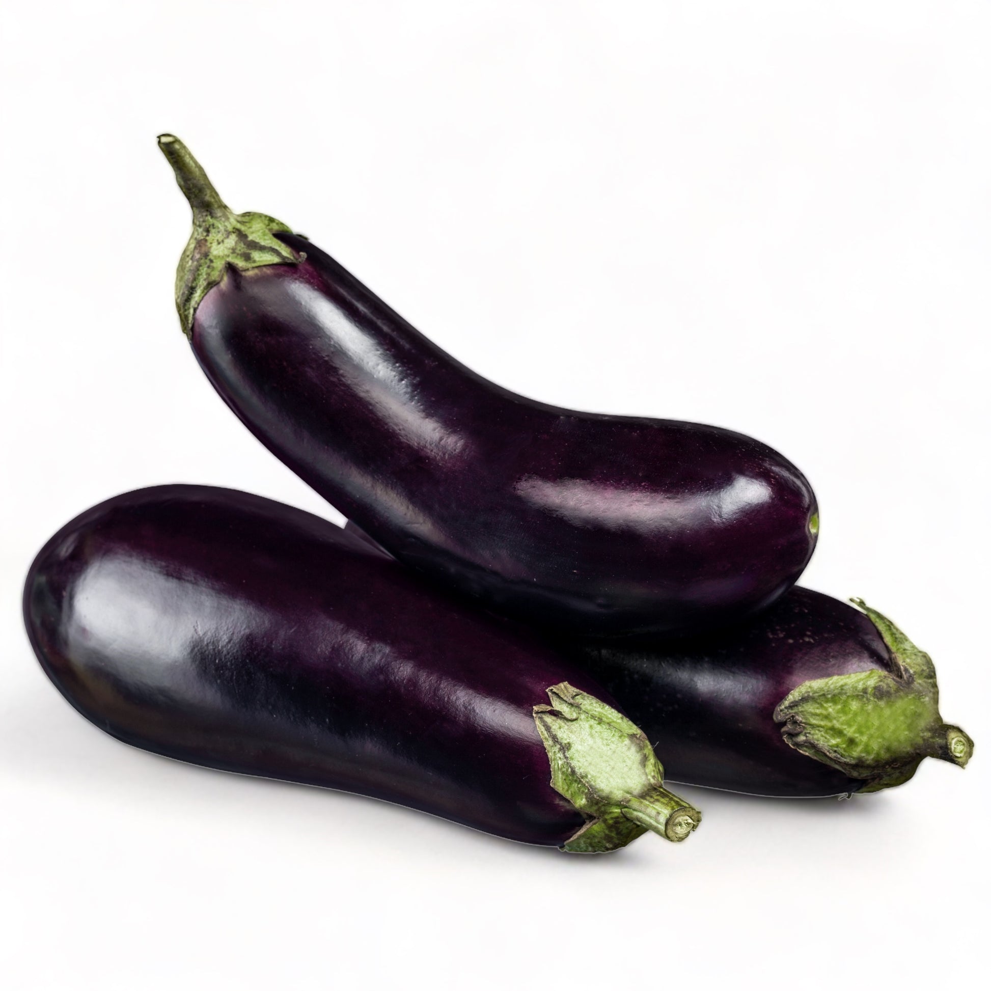Three fully grown Black Beauty eggplants against a white backdrop