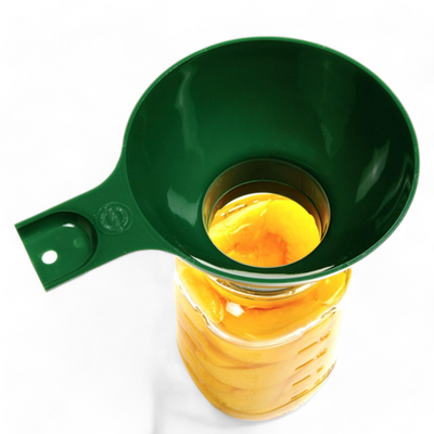 Green canning funnel from the 6-piece set positioned on a jar filled with fruit
