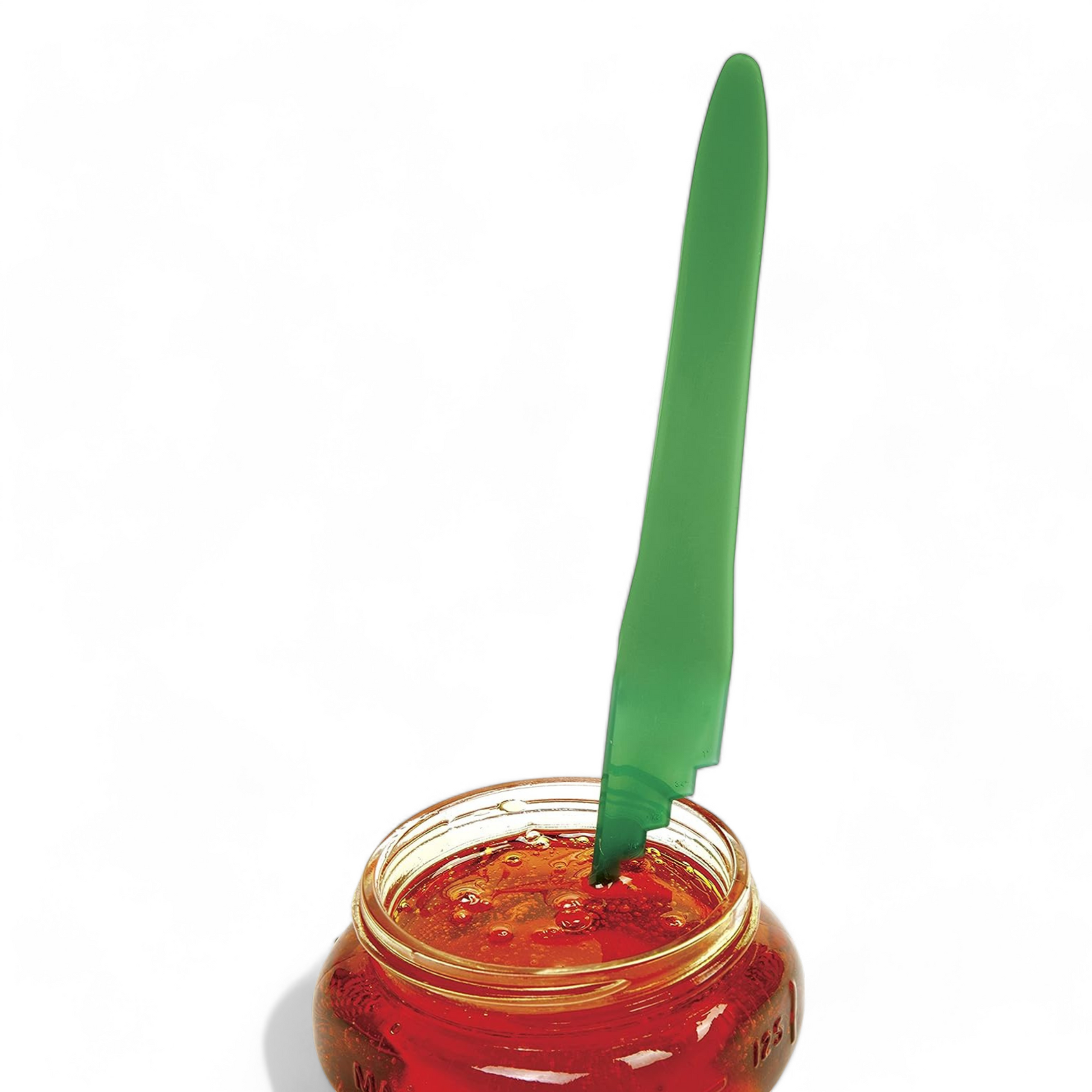 Green bubble popper measuring canning tool being used on a jar of honey