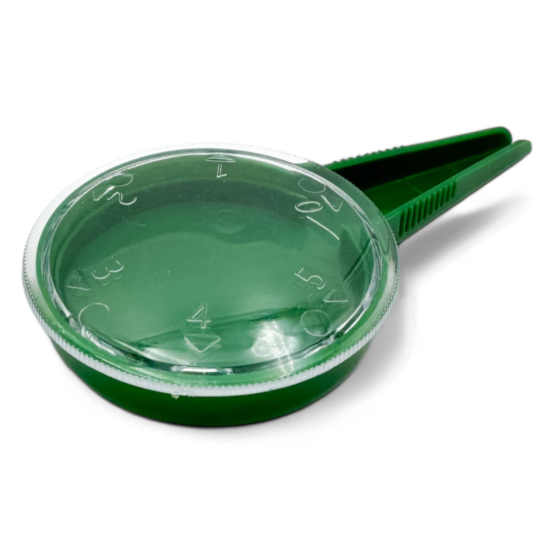 Green seed dispenser with lid and dispensing spoon on white surface