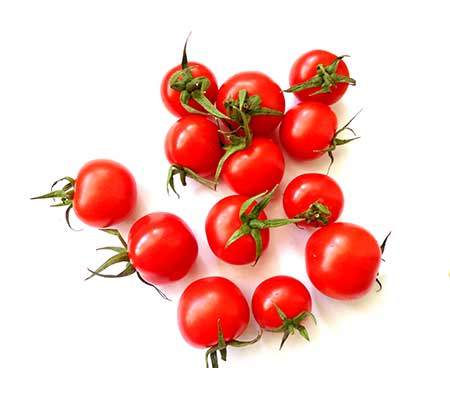 Multiple fully grown heirloom Large red cherry Tomatos displayed on a white background